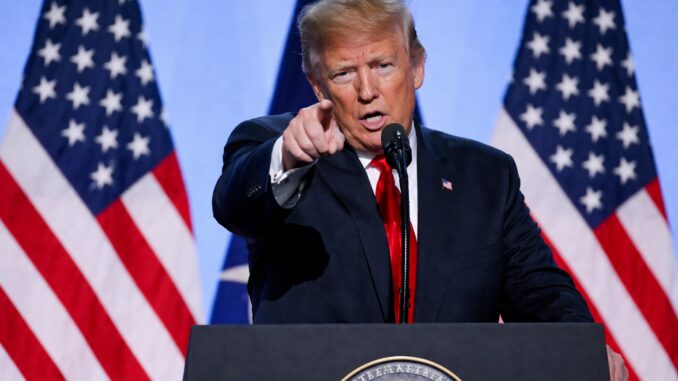 Speaker pointing with American flags behind podium. Speaker pointing with American flags behind podium.