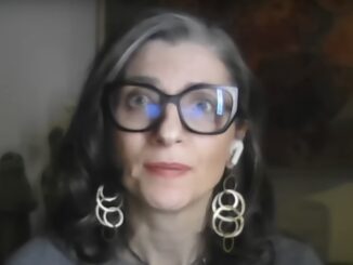 Woman with glasses and hoop earrings.