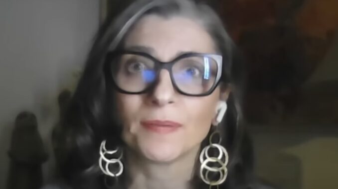Woman with glasses and hoop earrings.