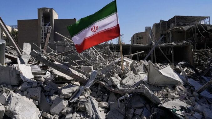 Iranian flag amidst building rubble and debris.