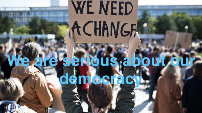 Protesters holding signs for democratic change.