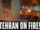 Tehran engulfed in large fire, night scene.