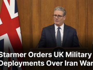 Man speaking at podium with UK flags.
