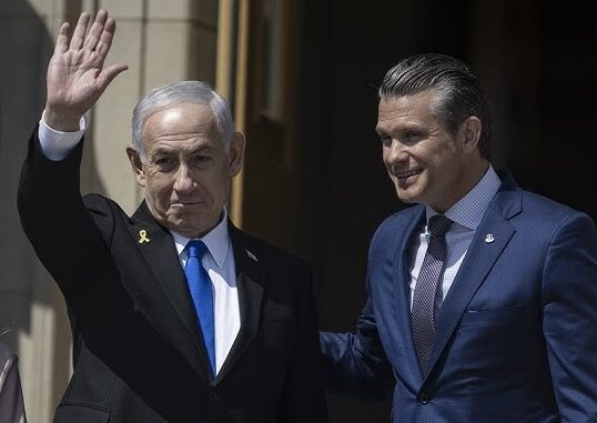 Two men in suits, one waving hand.