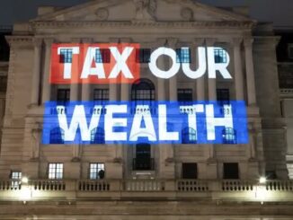Tax Our Wealth" projected on building facade.