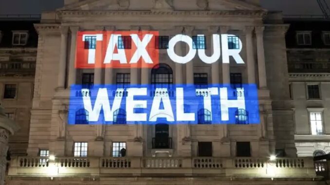 Tax Our Wealth" projected on building facade. Tax Our Wealth" projected on building facade.