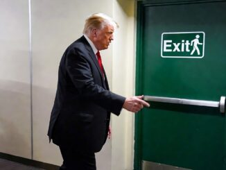Man opening a green exit door.