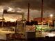 Industrial facility at sunset with smokestacks.