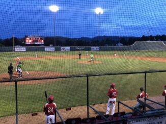 Night baseball game under bright stadium lights.
