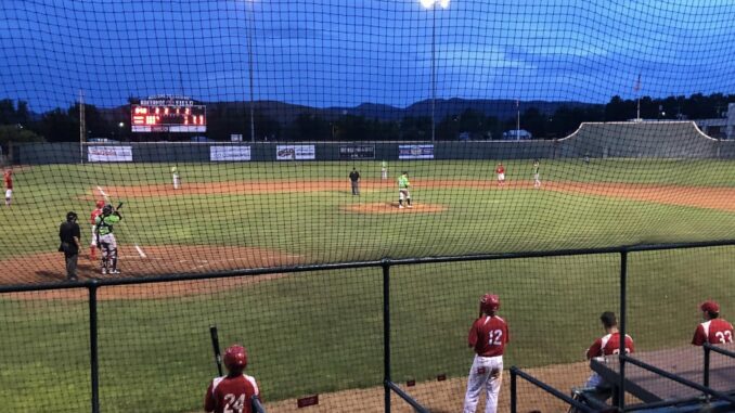 Night baseball game under bright stadium lights. Night baseball game under bright stadium lights.