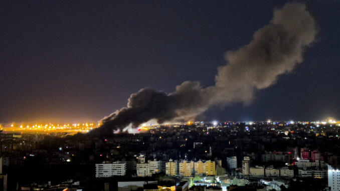 Cityscape at night with rising smoke plume. Cityscape at night with rising smoke plume.