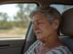 Elderly woman sitting in a car.
