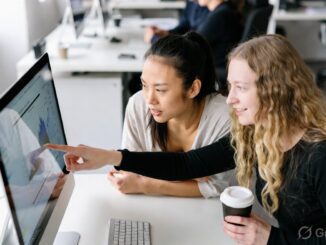 Two women collaborating at a computer screen.