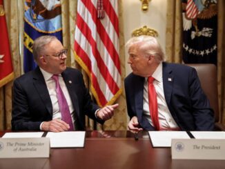 Two leaders talking at a meeting table.