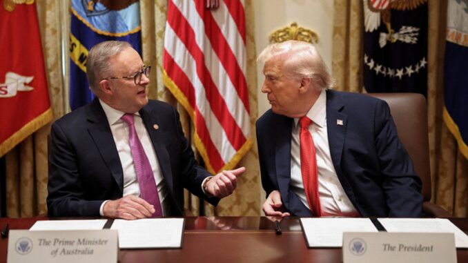 Two leaders talking at a meeting table.