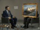 Interviewer faces person with framed ship painting