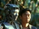 Man standing beside silver humanoid robot