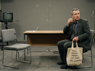 Man with bag sitting in empty room.