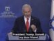 Man speaking at podium with Israeli flag