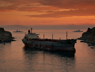 Large rusted ship anchored between cliffs at sunset