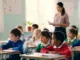 Elementary students listening in classroom with teacher