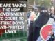 Protester in niqab holding watermelon fan
