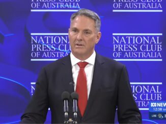 Man speaking at National Press Club podium