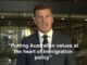 Man in suit speaking with immigration quote