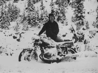 Person on snow-covered motorcycle in snowy forest