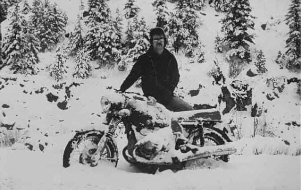 Person on snow-covered motorcycle in snowy forest