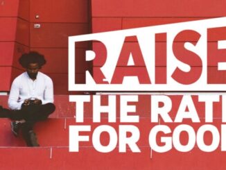 Person sitting near "Raise the Rate" sign