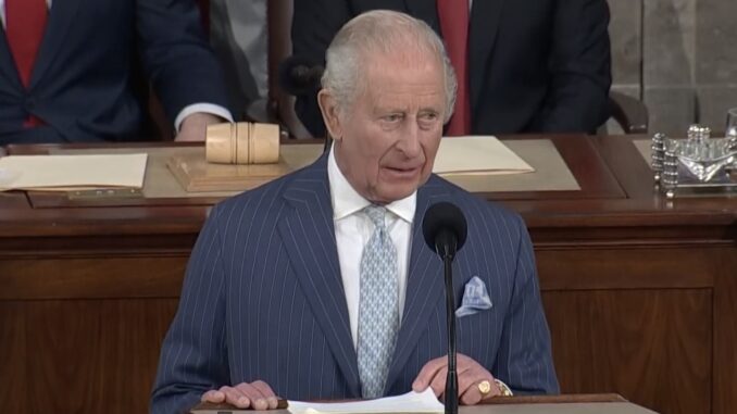 Elderly man in pinstripe suit speaking at podium