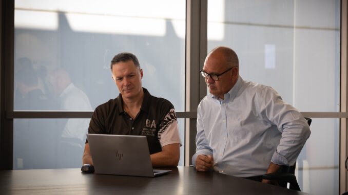 Two men discussing laptop in office Two men discussing laptop in office