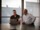 Two men discussing laptop in office
