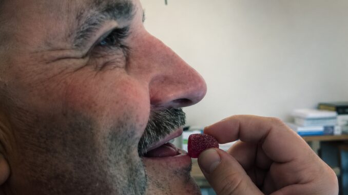 Close-up of man being fed a red berry