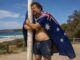 Man draped in Australian flag hugging pole
