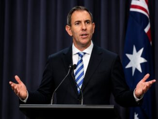 Man speaking at podium with Australian flag