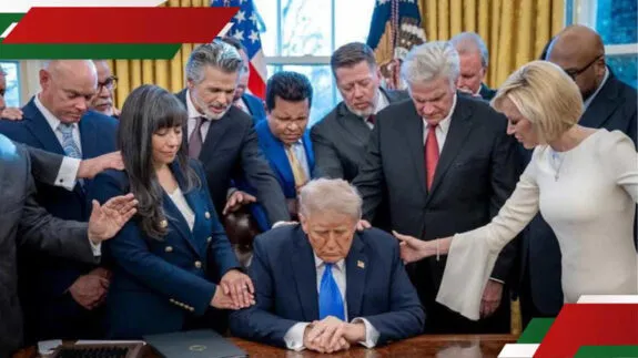 People praying around seated man at desk People praying around seated man at desk