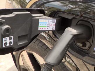 Electric car charging plug connected to vehicle