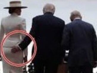 Three people from behind, hand on woman's hip