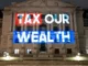 Illuminated "Tax Our Wealth" projected on building