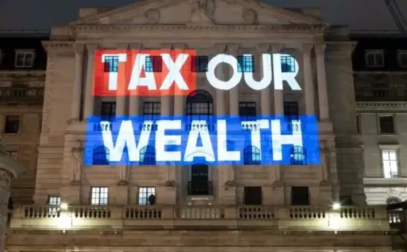 Illuminated "Tax Our Wealth" projected on building Illuminated "Tax Our Wealth" projected on building