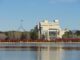Government building and flag reflected in lake