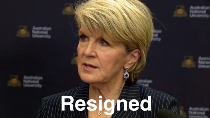 Woman at podium with "Resigned" overlay