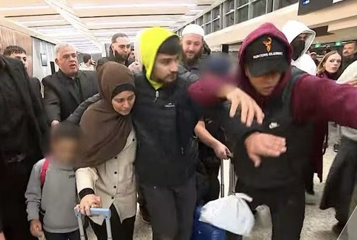 Group moving through crowded airport terminal