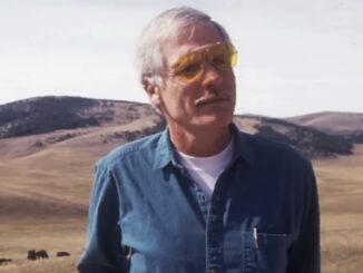 Older man in yellow glasses on grassland