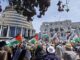 Protest crowd with Palestinian flags at parliament