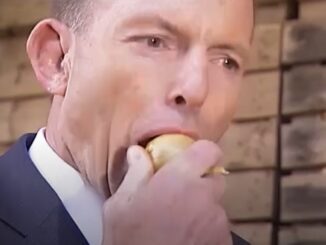 Man in suit biting into round pastry