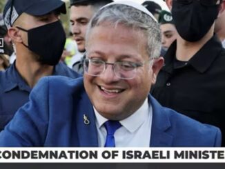 Smiling man in suit amid protesters