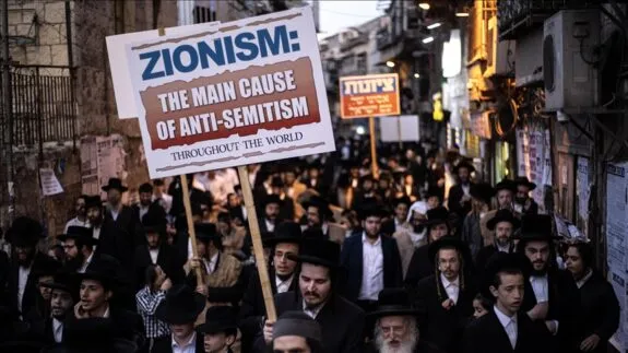 Crowd protest with sign reading "ZIONISM
